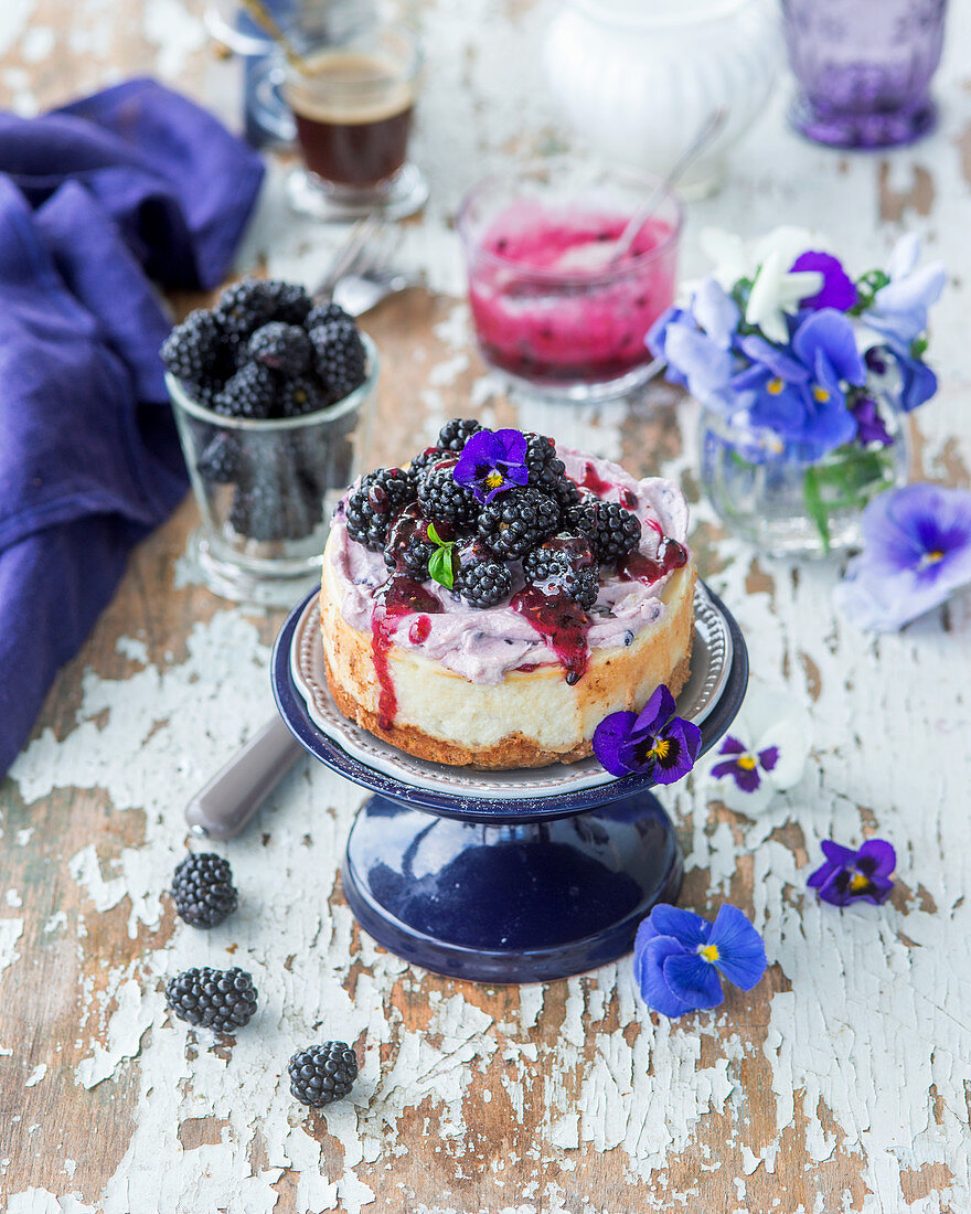 Blackberry cheesecake with blackberry sauce and edible flowers