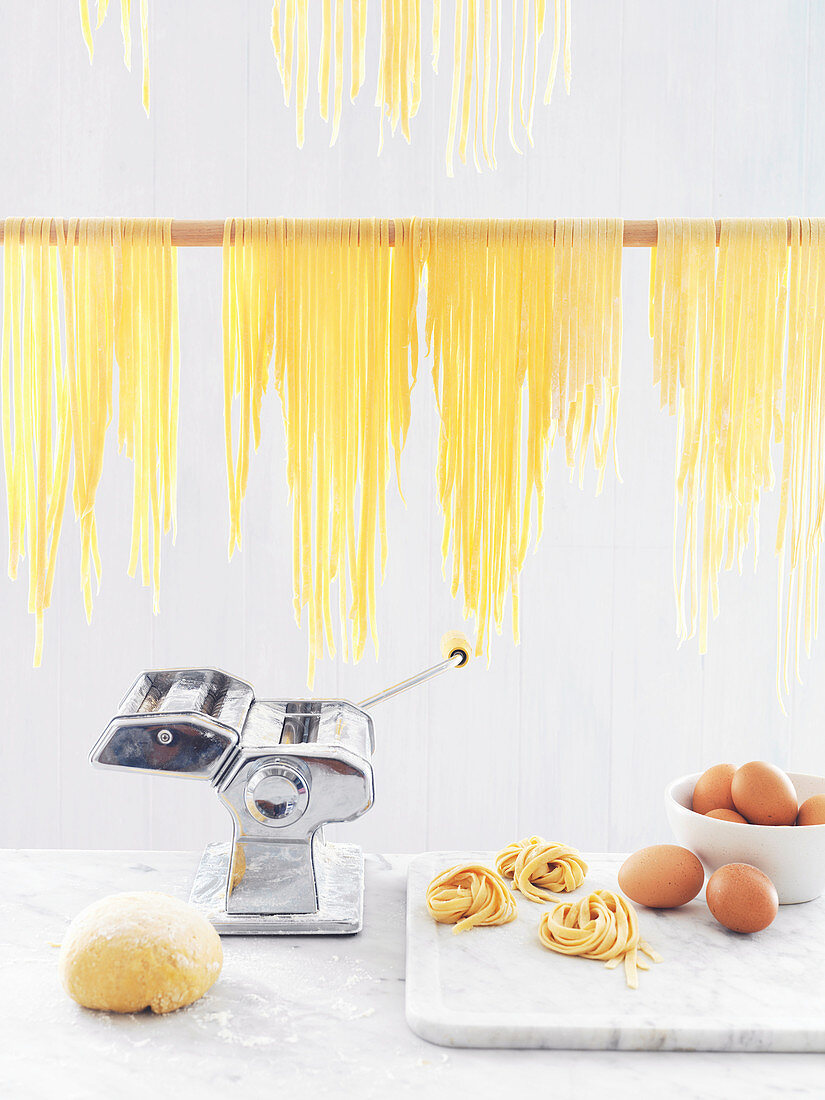 Home-made pasta with a pasta maker, pasta dough and eggs