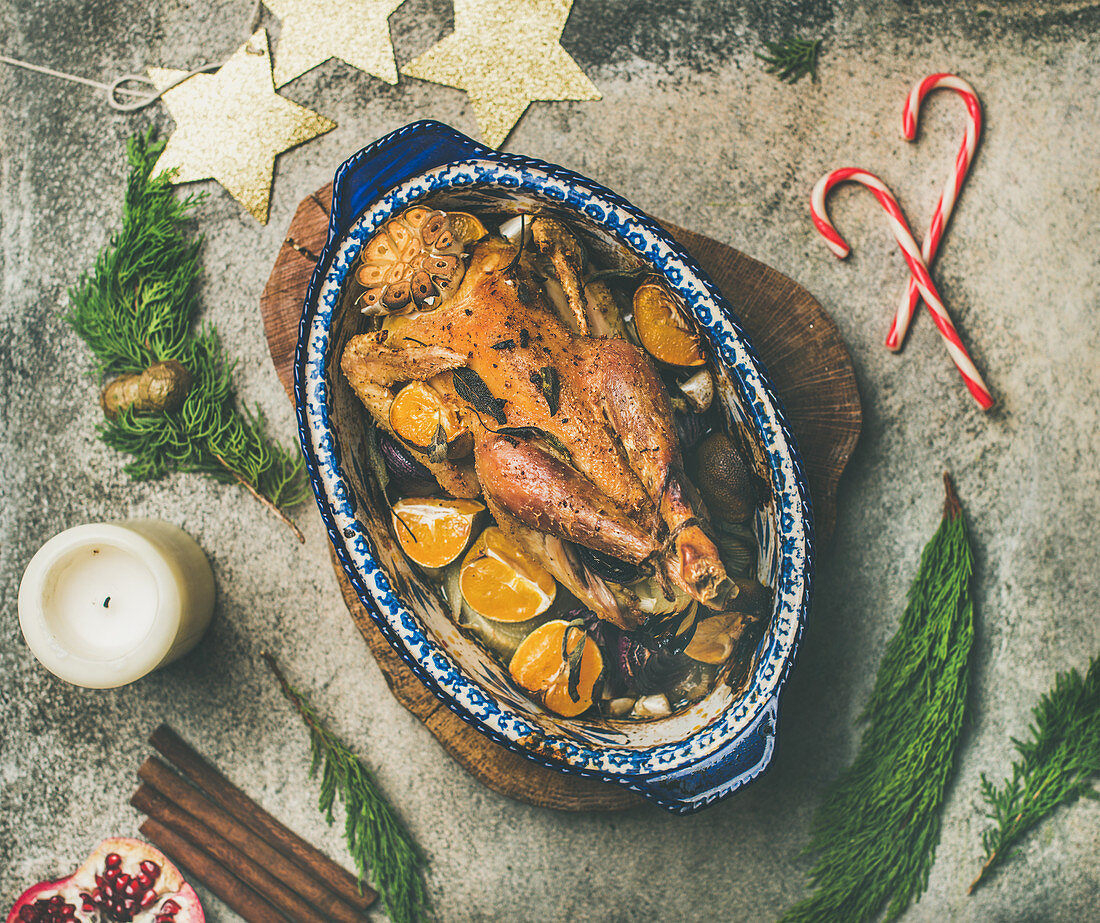 Roasted chicken for Christmas eve celebration table with holiday decorations on wooden board