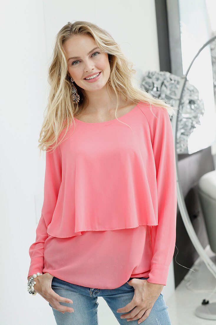A blonde woman wearing a long-sleeved, layer-look top