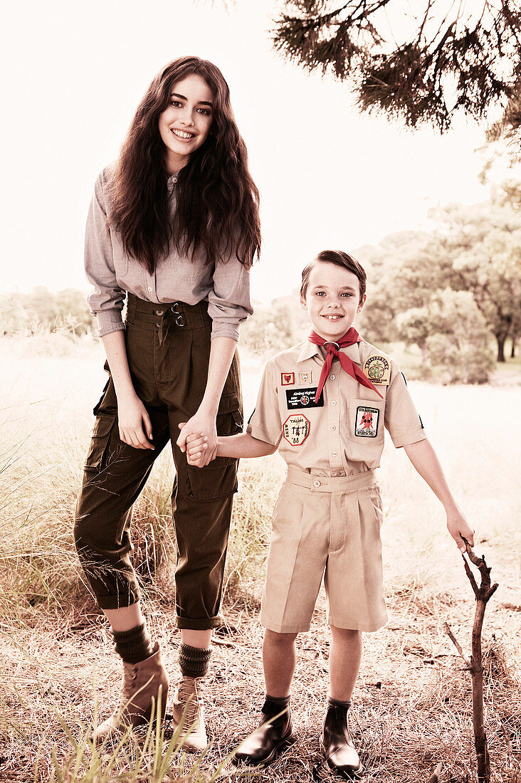 A dark-haired woman with a boy wearing a uniform