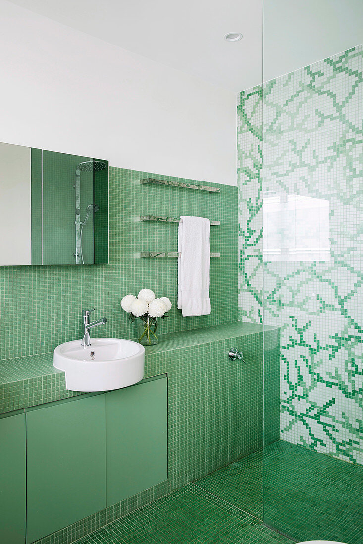 Blick ins Badezimmer mit grünen und grün-weißen Mosaikfliesen