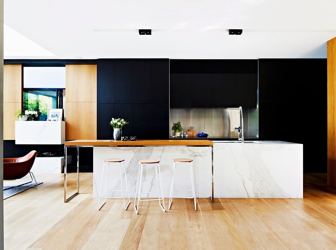 Kitchen island with marble cladding in an open designer kitchen