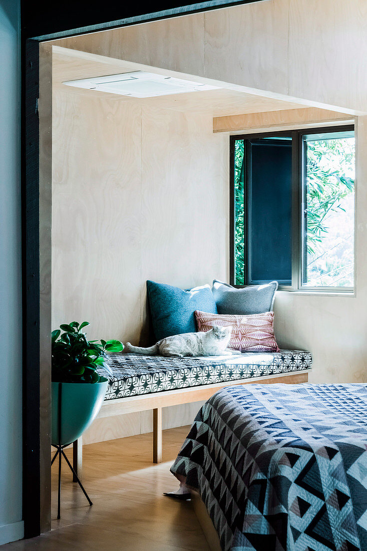 Cozy day bed with pillows and cat in the bedroom