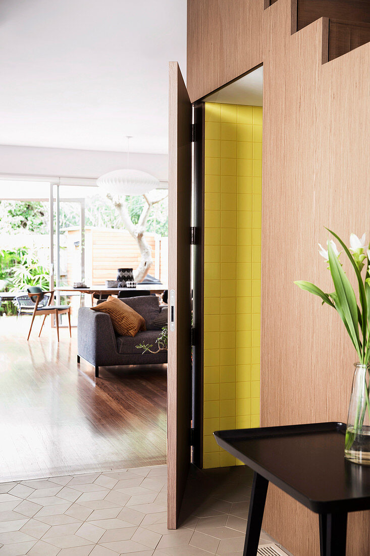 View from the hallway with a tray table and an open bathroom door into an open living room