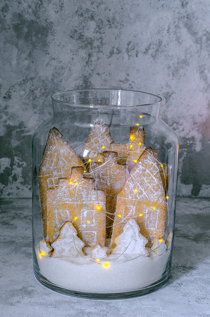 Lebkuchenhäuser mit Lichterkette im Glasgefäss