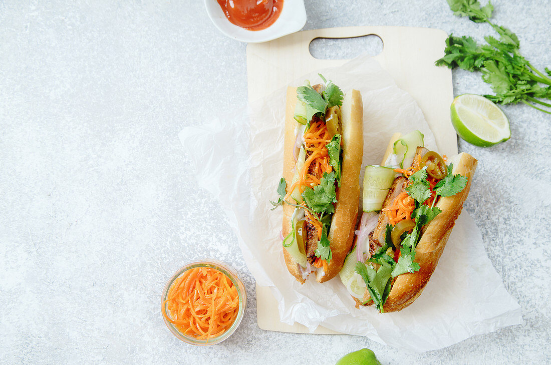 Banh-Mi-Sandwich mit gegrilltem Schweinefilet, Karotten, Gurken, Jalapeno und Koriandergrün