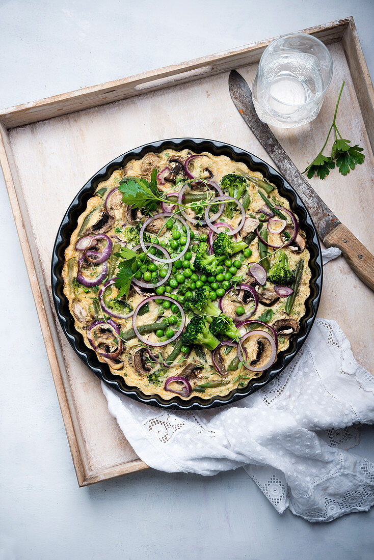 Vegan frittata with beans, peas, broccoli, mushrooms and onions