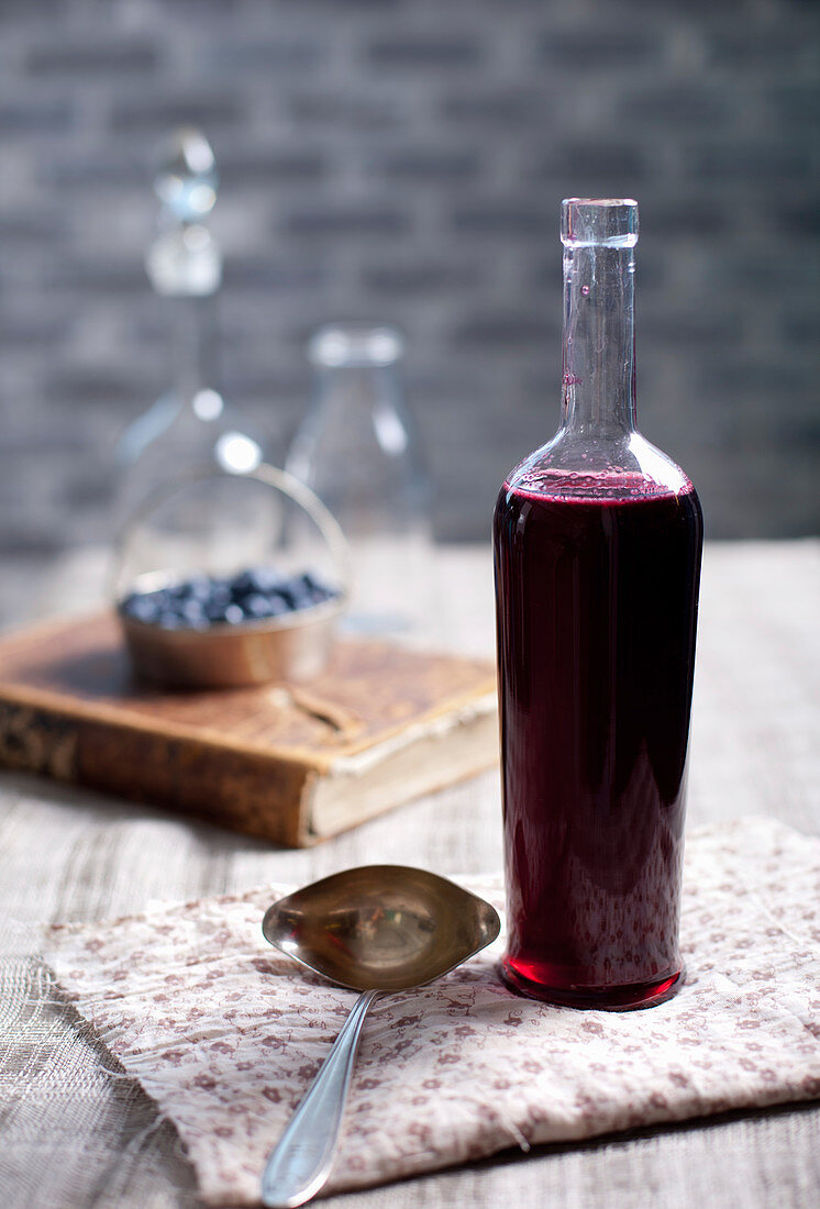 Vintage-Flasche mit hausgemachtem Essig aus schwarzen Johannisbeeren, Blaubeeren und Brombeeren