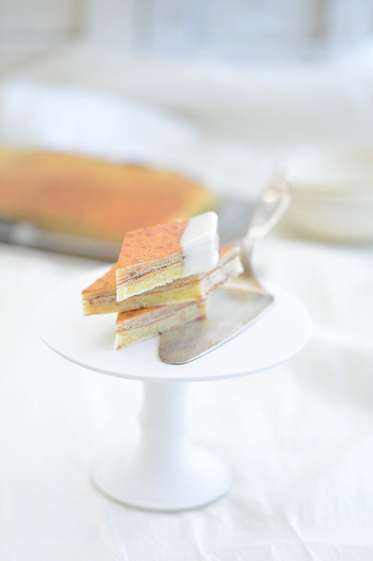 Baumkuchen corners (German layer cake) with a cake slice on a cake stand