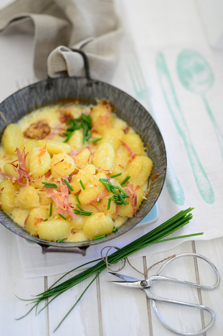 Gratin gnocchi with raw ham and chives