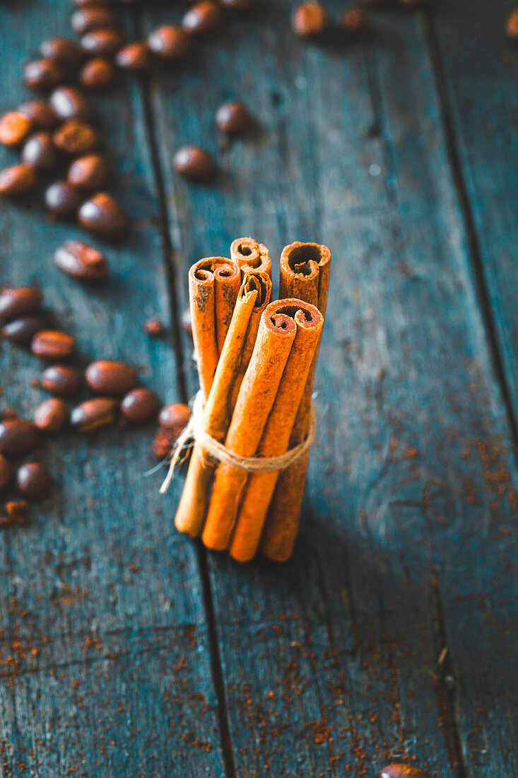 Coffee beans and cinnamon sticks on wood