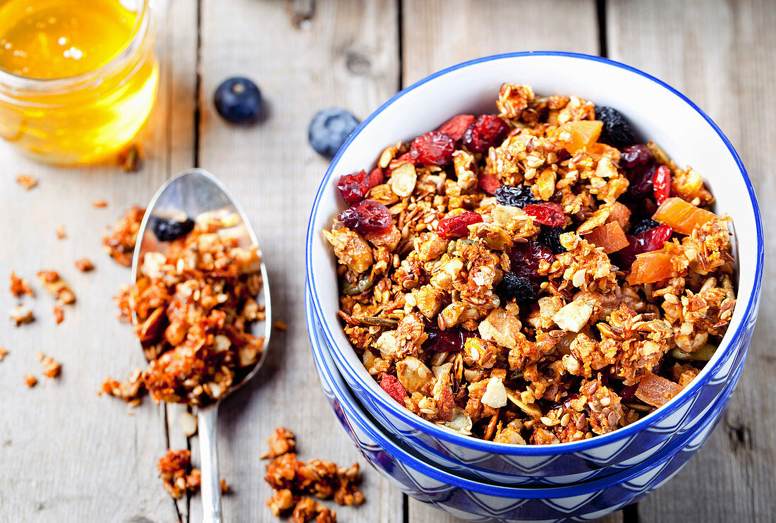 Müsli mit Haferflocken, Honig, Nüssen, Beeren und Leinsamen