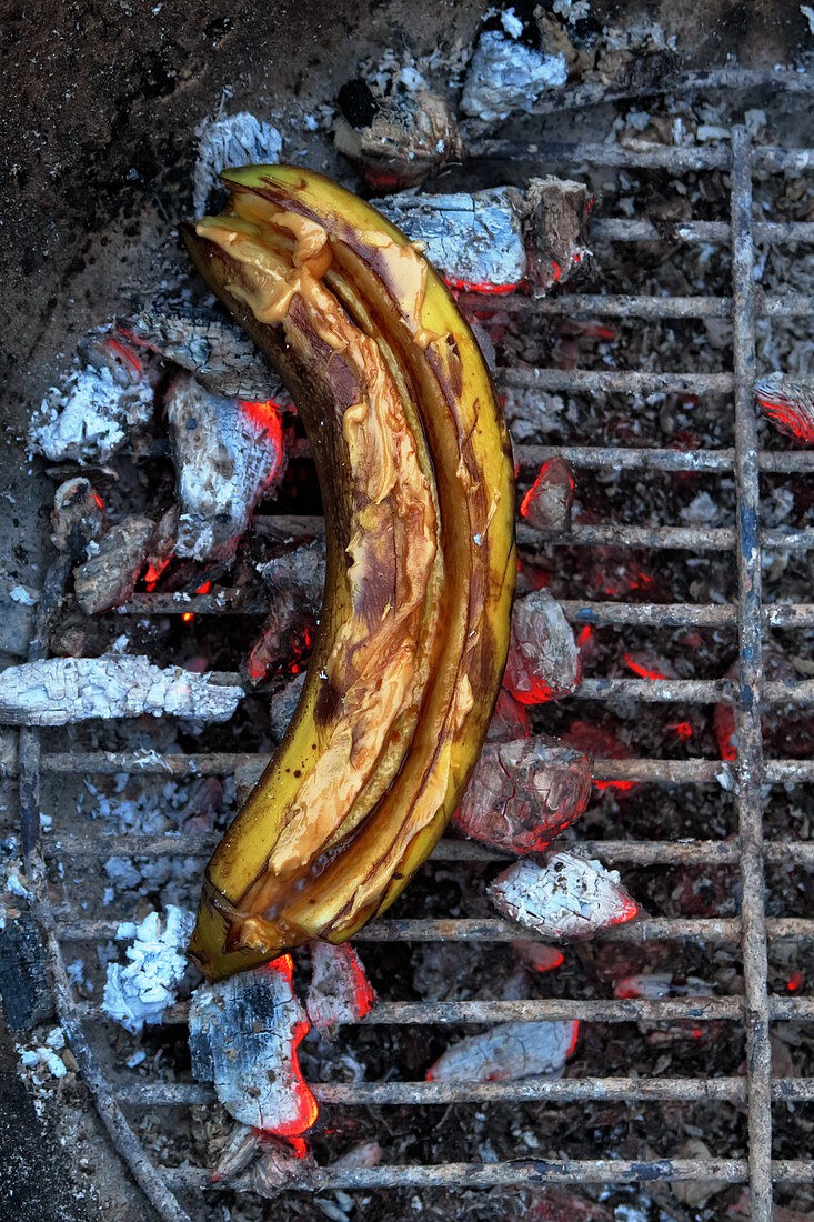 A banana filled with honey on a grill (top view)