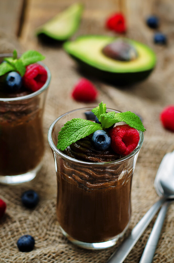 Roh veganer Schokoladen-Avocado-Pudding mit Beeren und Minze