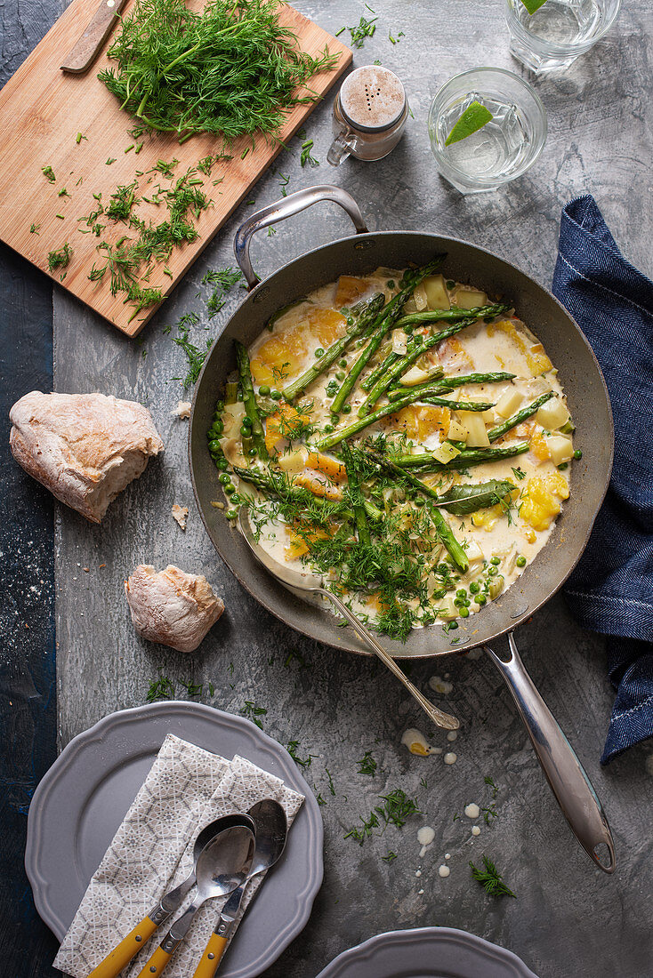 Smoked haddock with asparagus, peas, potatoes and dil in creamy garlic sauce