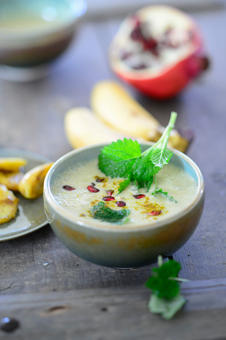 Curry and banana soup with coconut milk and pomegranate seeds
