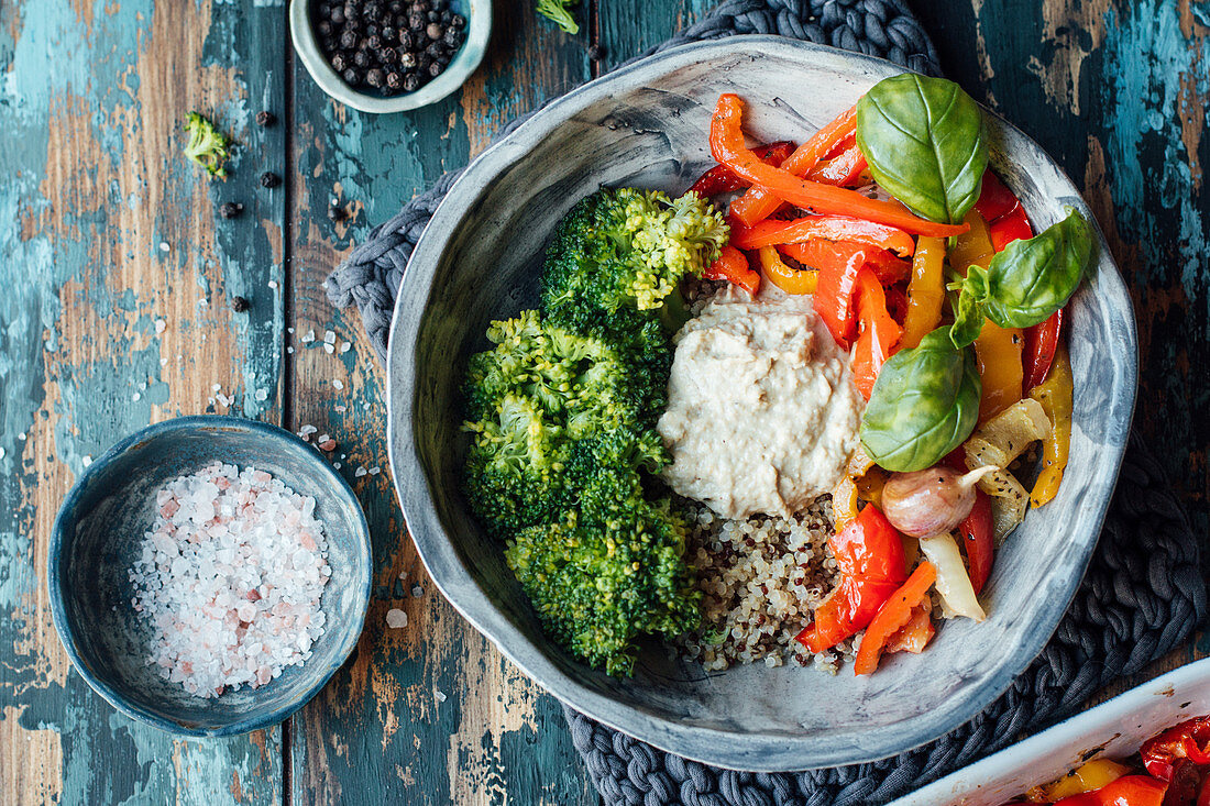 Paprikagemüse mit Knoblauch und Basilikum, Brokkoli, Quinoa und Hummus in einer Schale