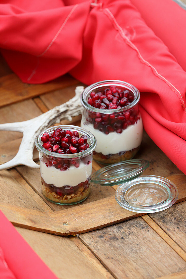 Bavarian cheesecake with pomegranate seeds in glass jars