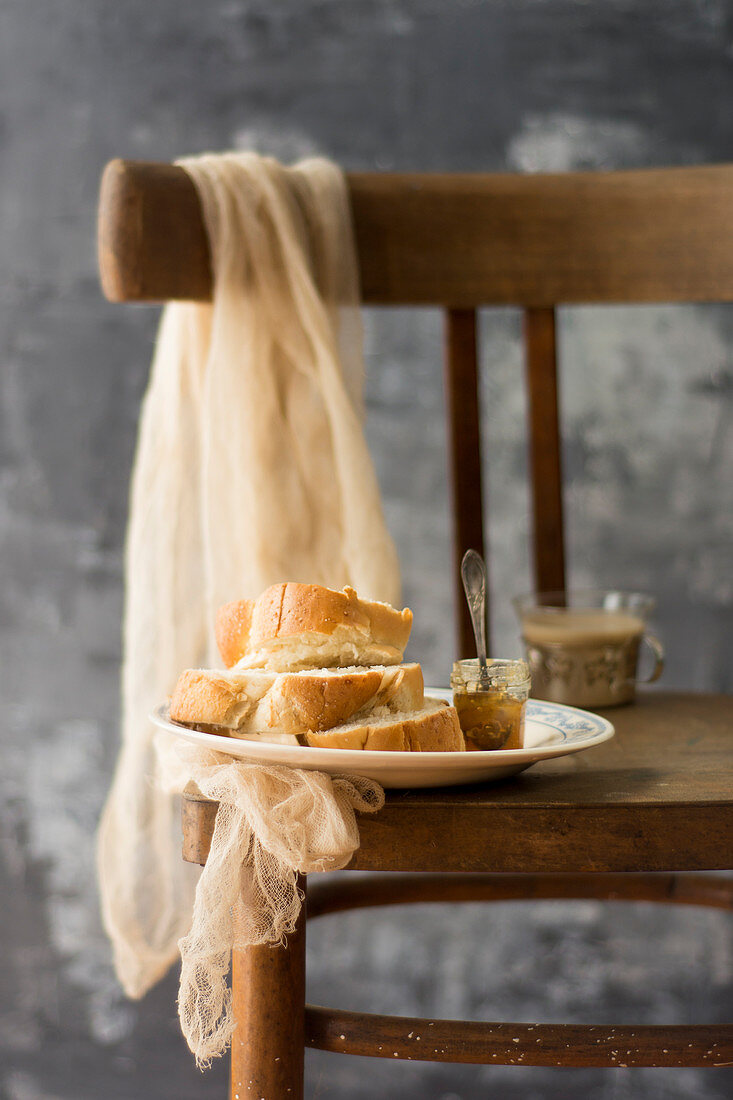 Hefebrötchen mit Marmelade auf einem Holzstuhl