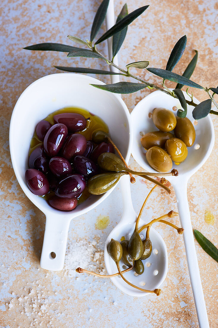 Oliven und Kapernäpfel in Schälchen
