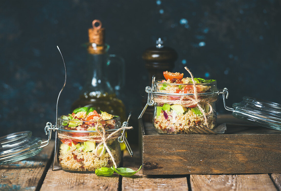 Homemade jar quinoa salad with cherry and sun-dried tomatoes, avocado and fresh basil