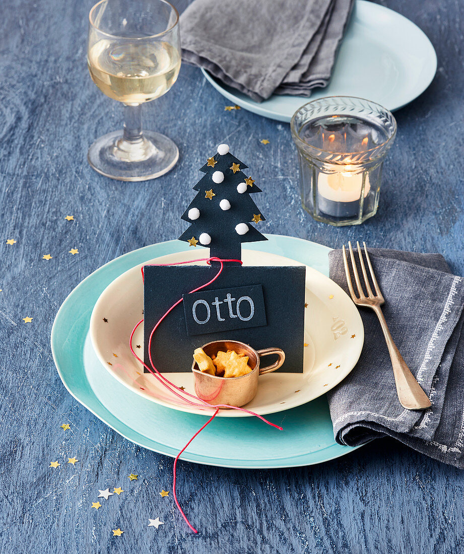 A Christmas table setting with a name card