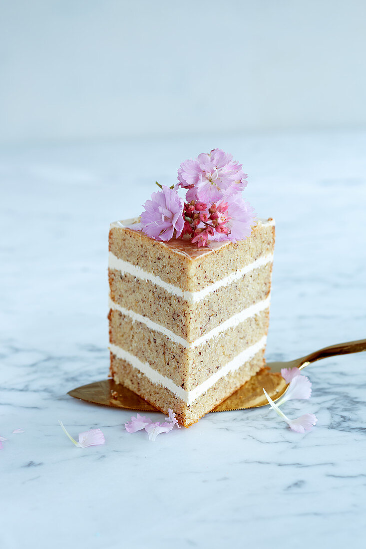 A slice of nut cake with a cream filling on a cake slice