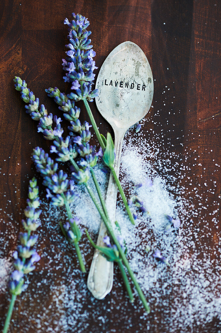 an arrangement of lavender flowers, sugar and a spoon