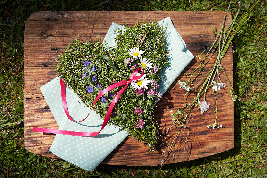 Herzförmiges Gesteck aus Blüten von Leinkraut, Frauenmantel, Majoran und Natterkopf