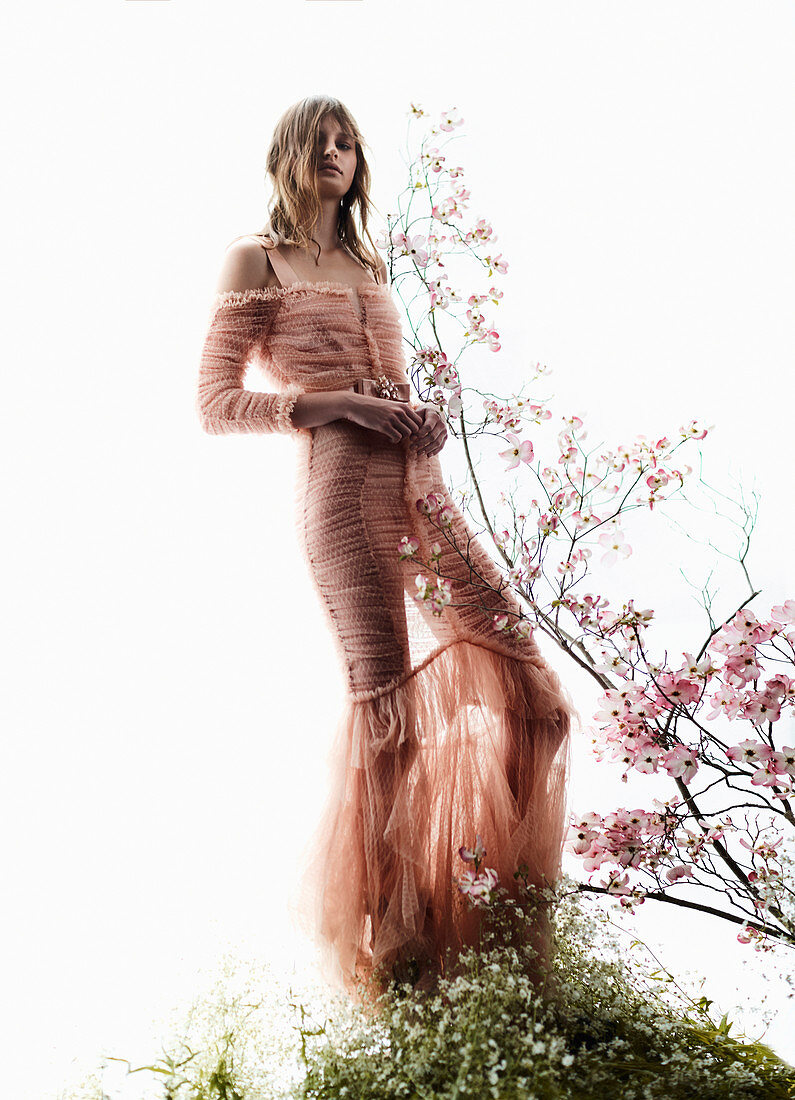 A young woman wearing an elegant salmon-coloured dress