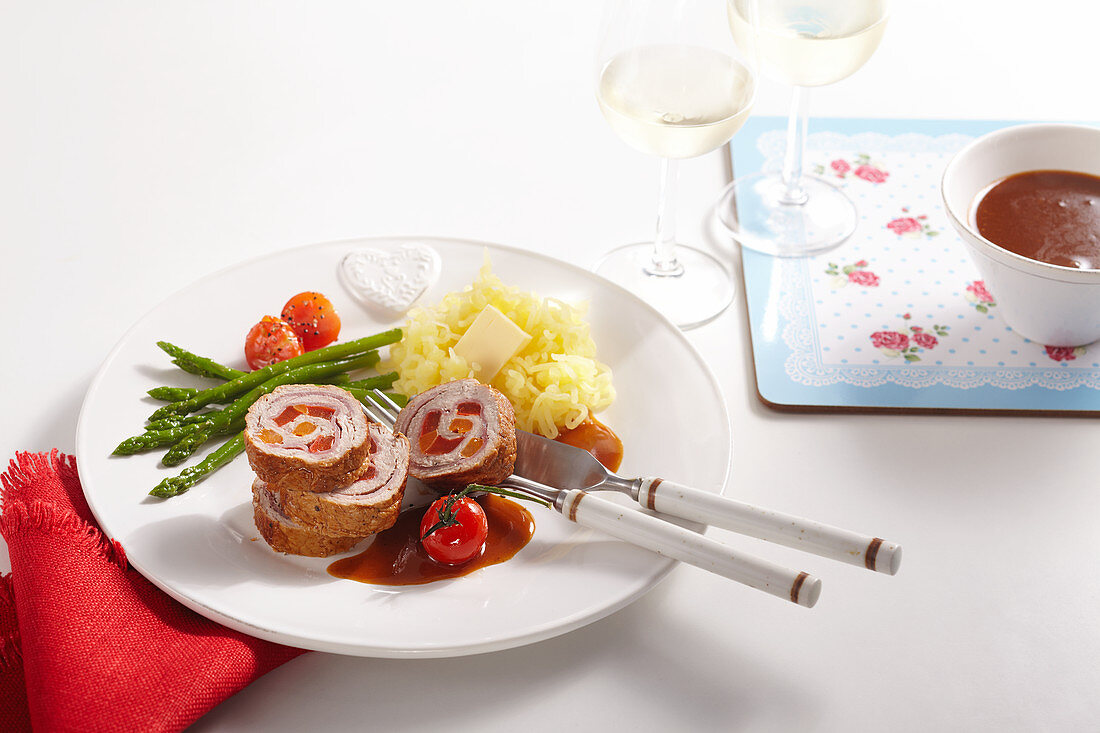Veal roulade filled with vegetables, green asparagus, cherry tomatoes, mashed potatoes and gravy