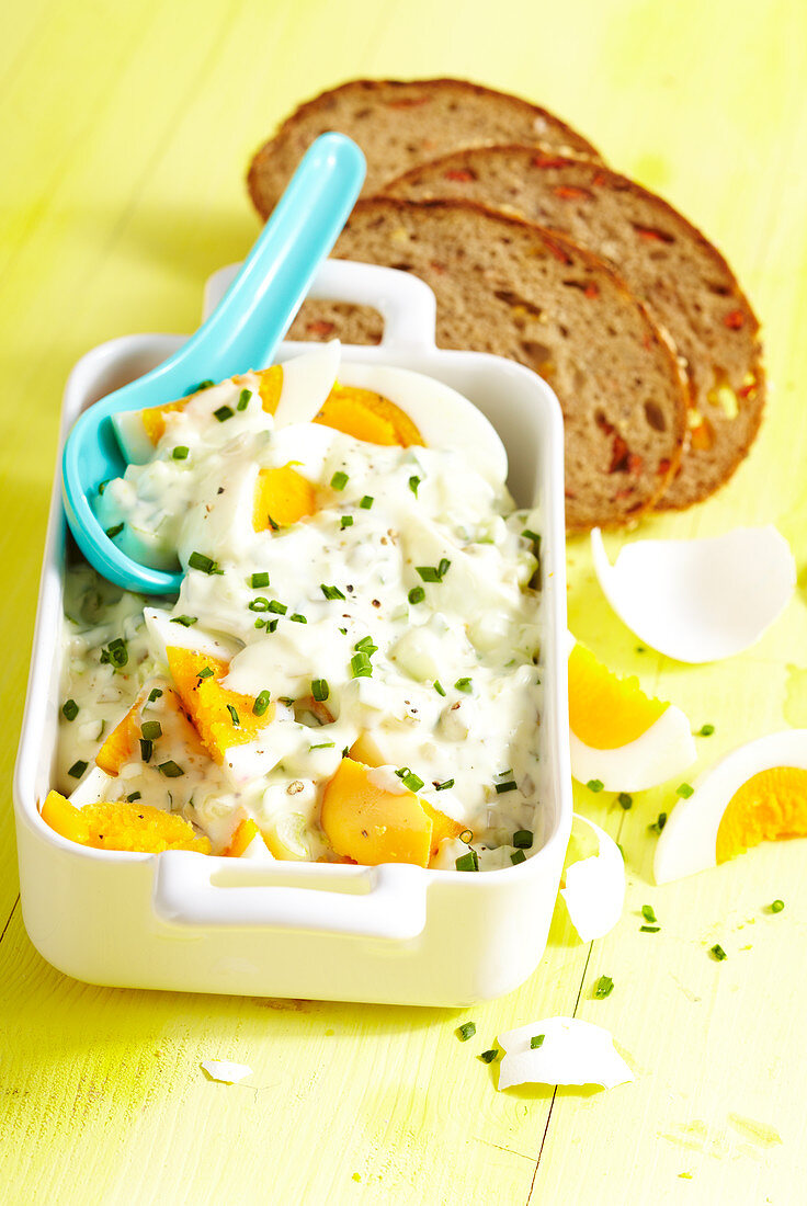 Egg salad with cucumber and chives served with sliced tomato bread