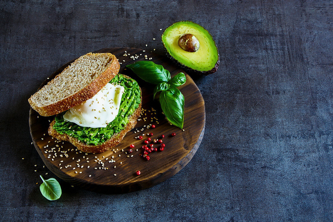 Healthy avocado and poached egg sandwich with sesame seeds