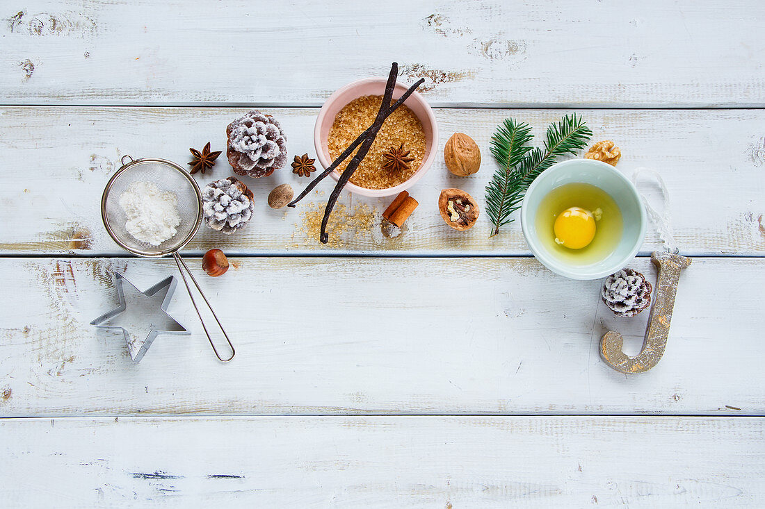 Christmas baking frame made of sugar, egg, flour, larch branch, pine cones, vanilla sticks, anise star and nuts