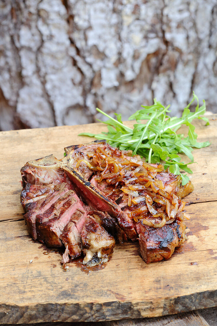 Grilled porterhouse steak with onions and rocket