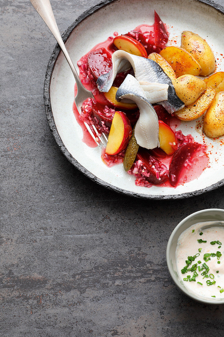 Pickled herring fillets with potatoes and beetroot in an elderflower marinade