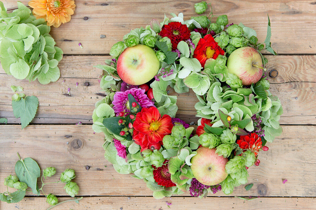 Late-summer wreath of hops, green hydrangeas, zinnias and apples