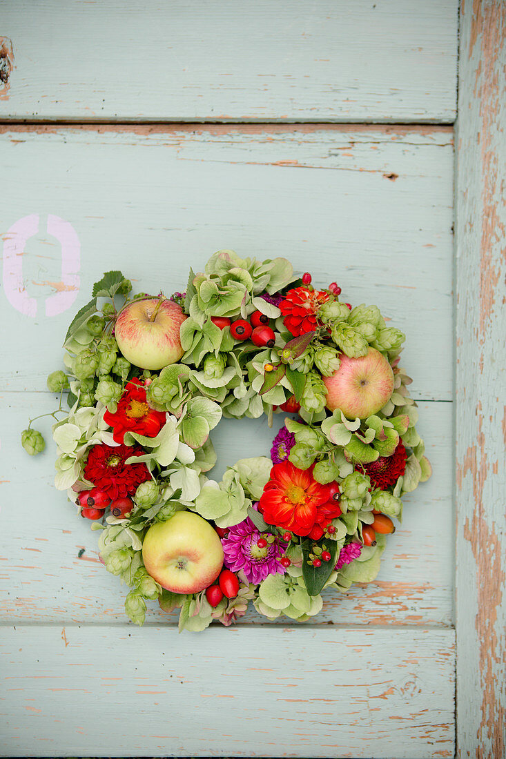Late-summer wreath of hops, green hydrangeas, zinnias and apples