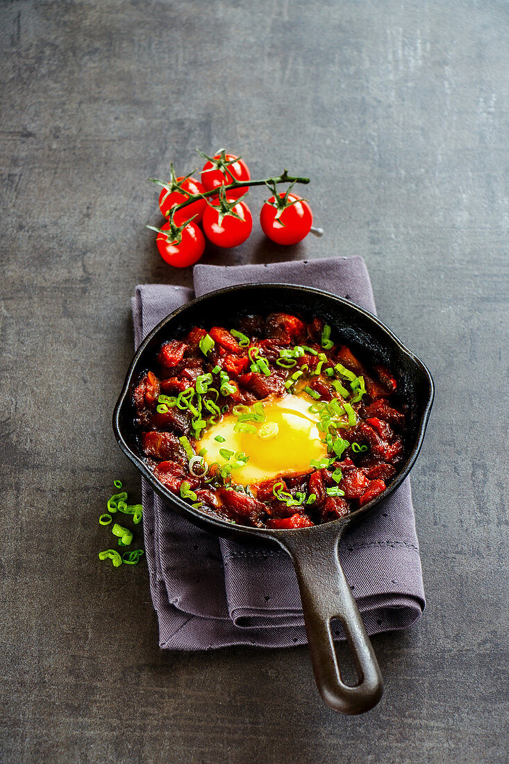 Close up of vegetarian shakshuka in vintage cast iron pan (Eggs in tomato sauce)