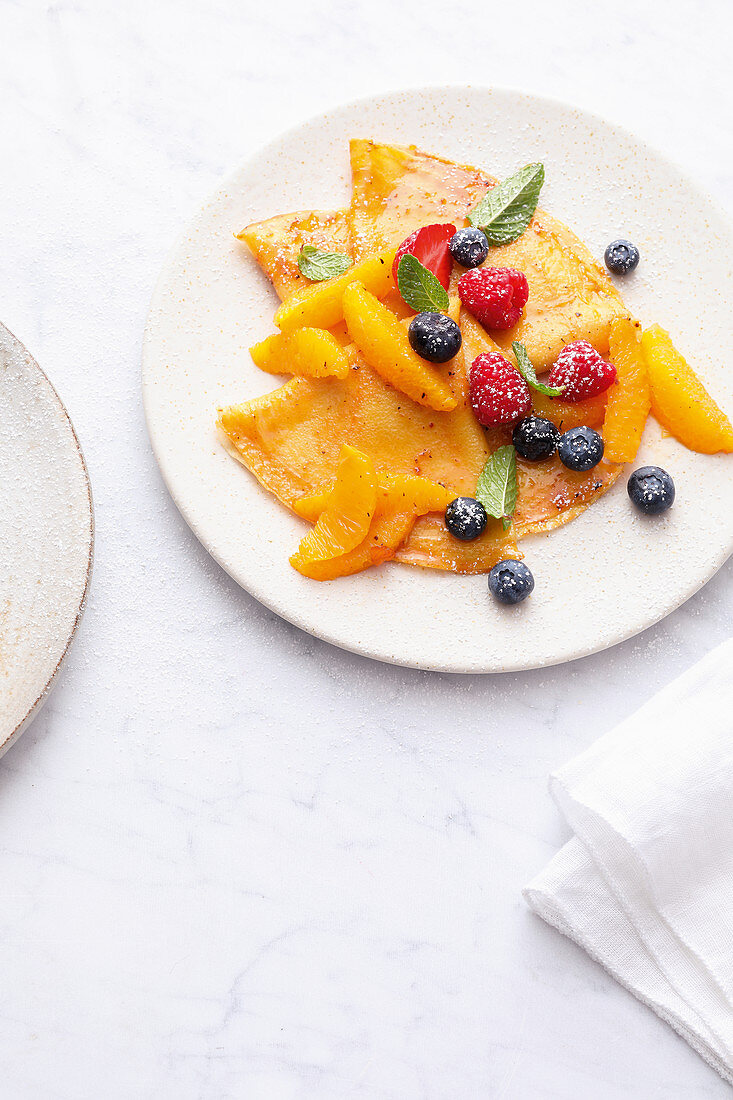 Crêpes mit Orangenragout und frischen Beeren