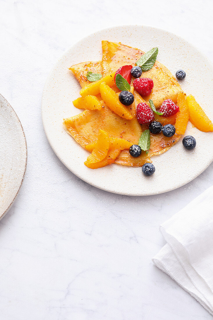 Crepes with oranges and fresh berries