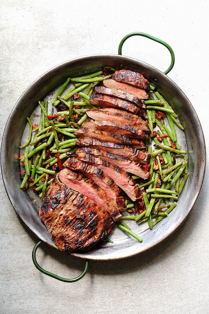 Gegrilltes Flanksteak mit Bohnen und getrockneten Tomaten