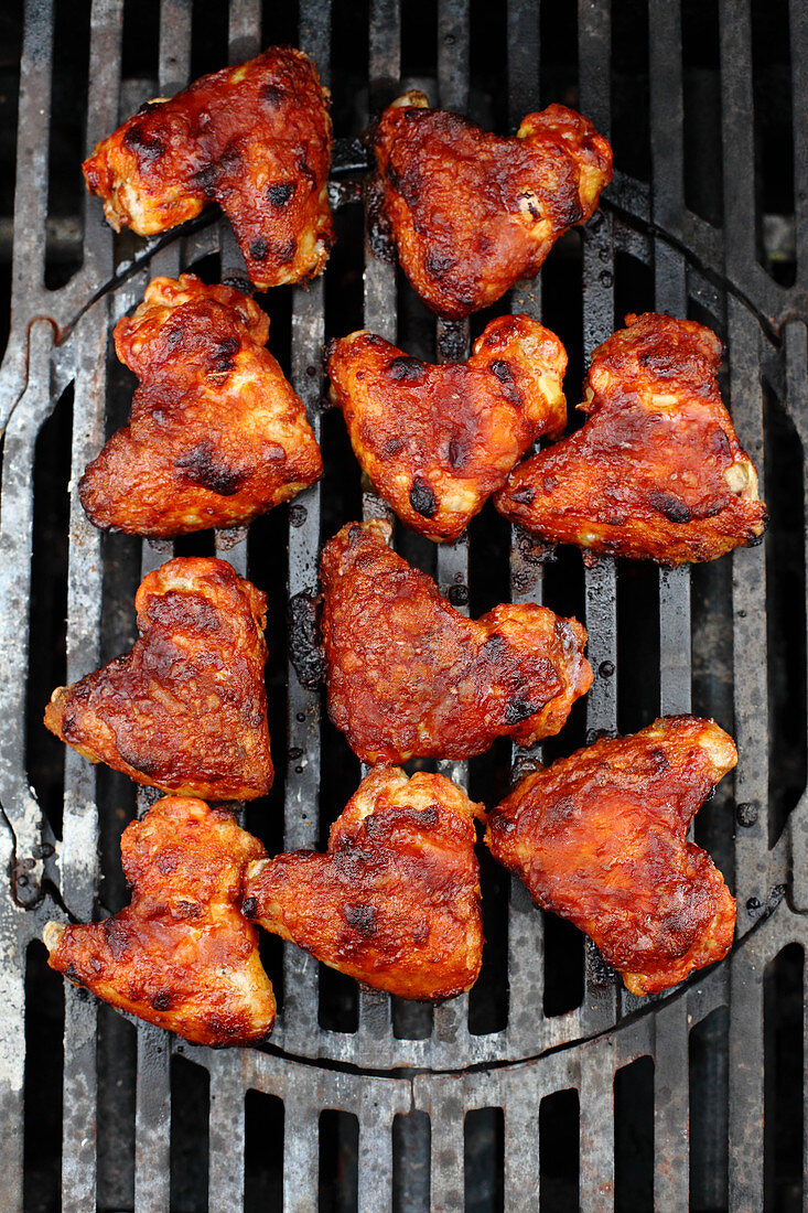 Sweet and sour chicken wings on a grill