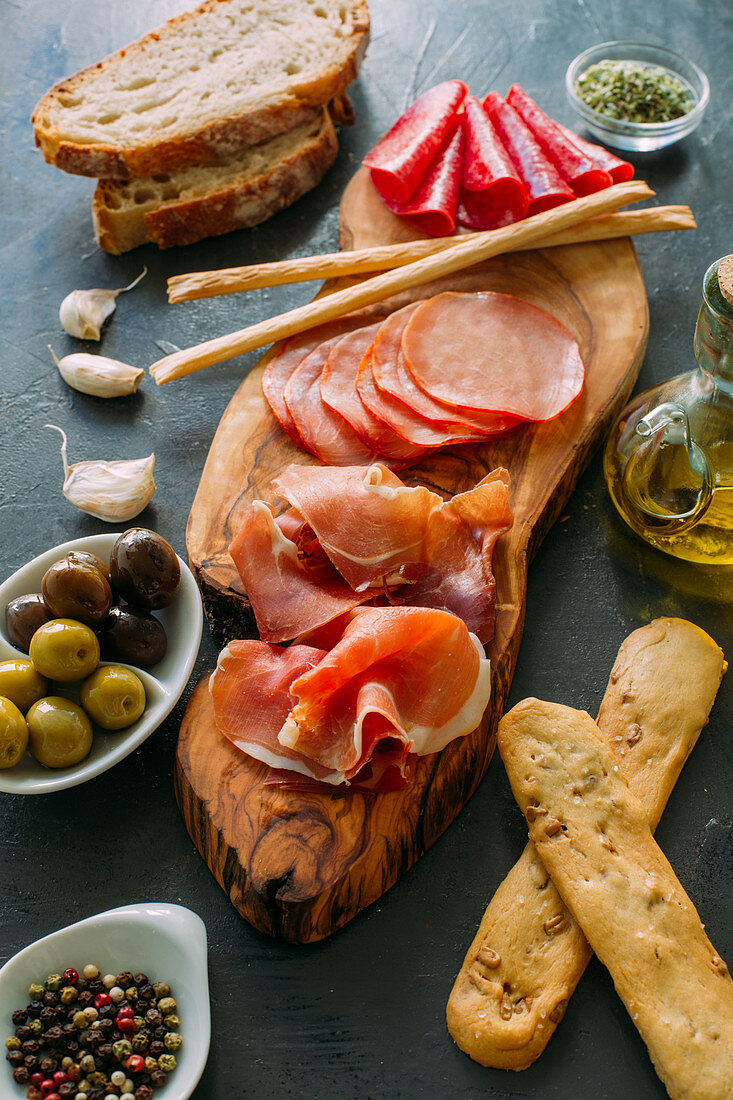 Wooden board with italian antipasti