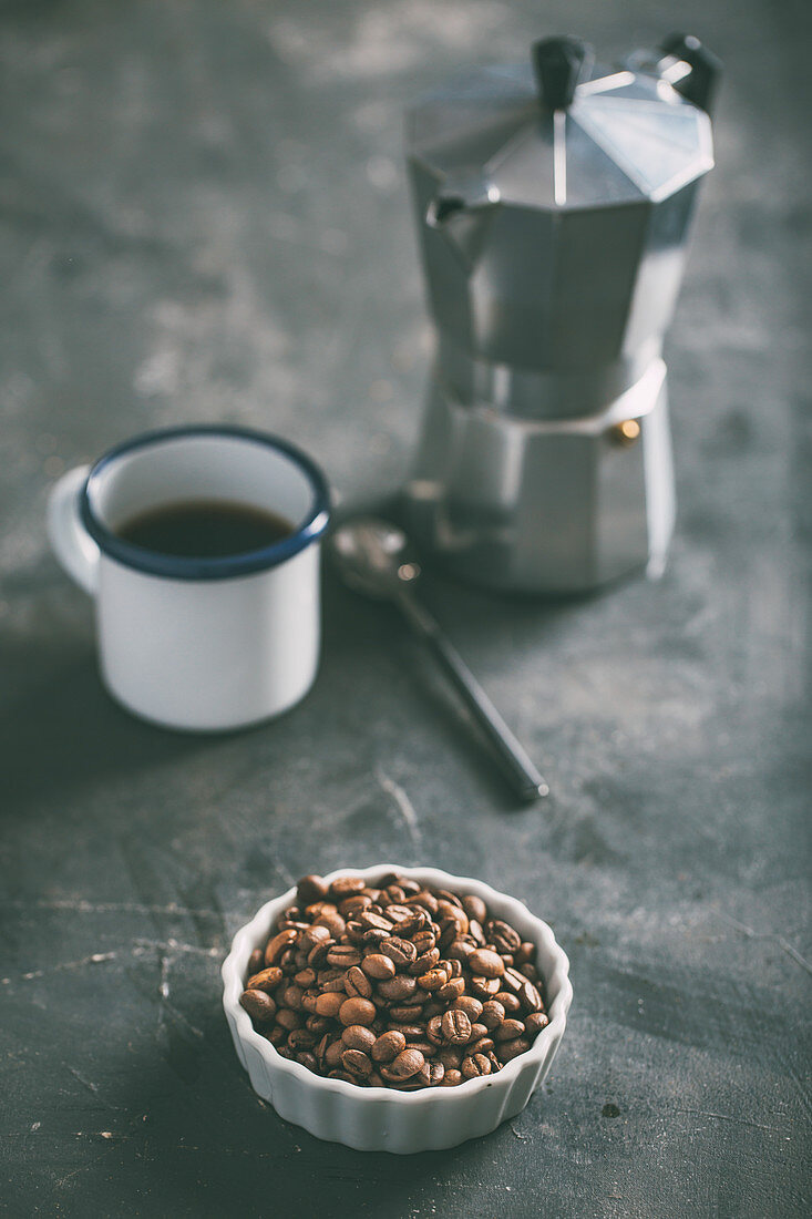 Coffee cup with coffee beans on dark background