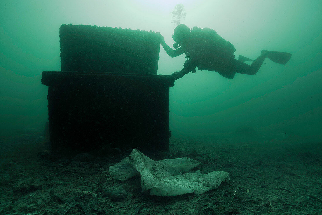 Diver with marine waste polluting the seabed