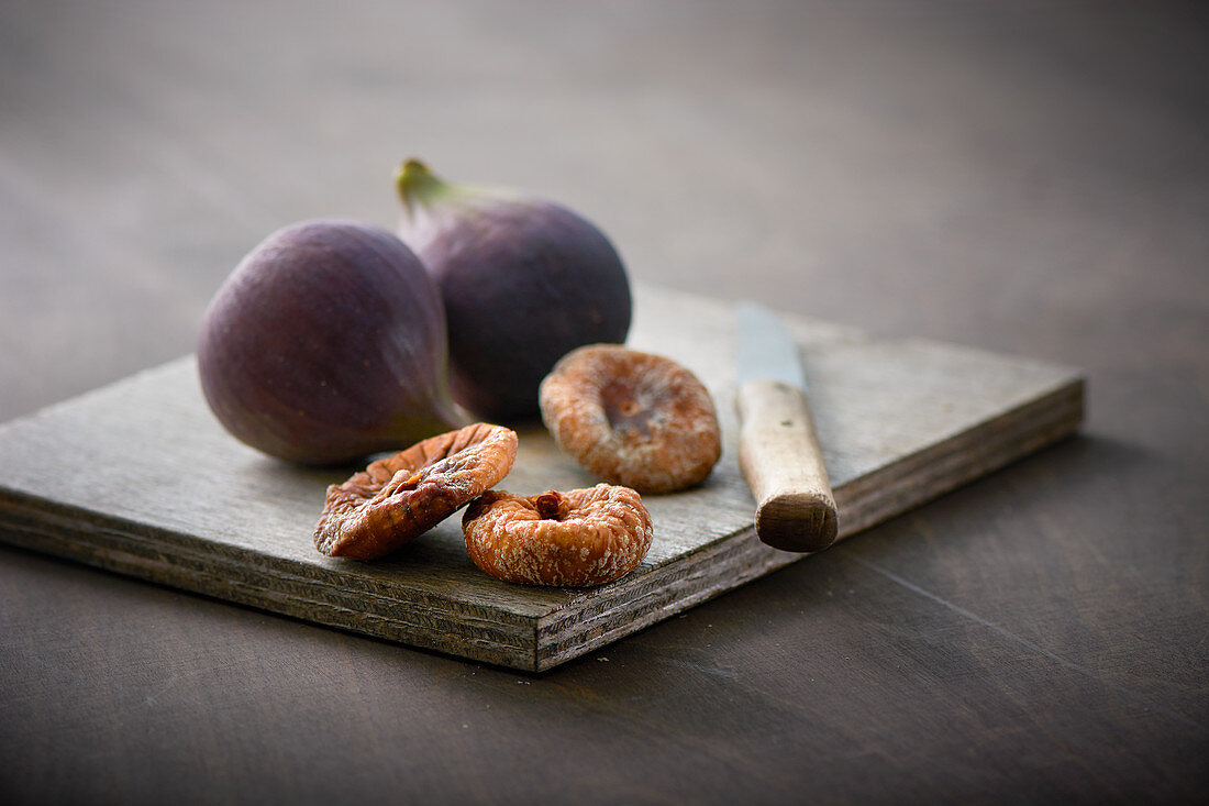 Fresh and dried figs on a wooden board