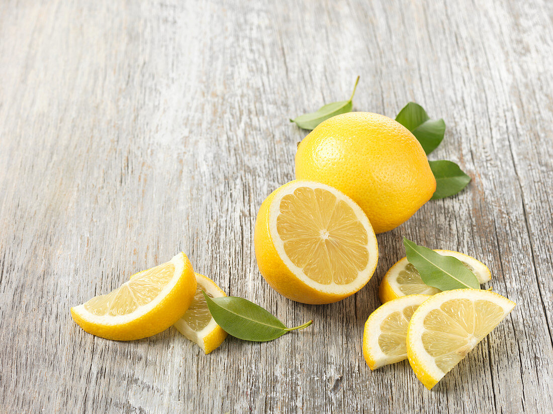 Zitronen, ganz, halbiert und Schnitze