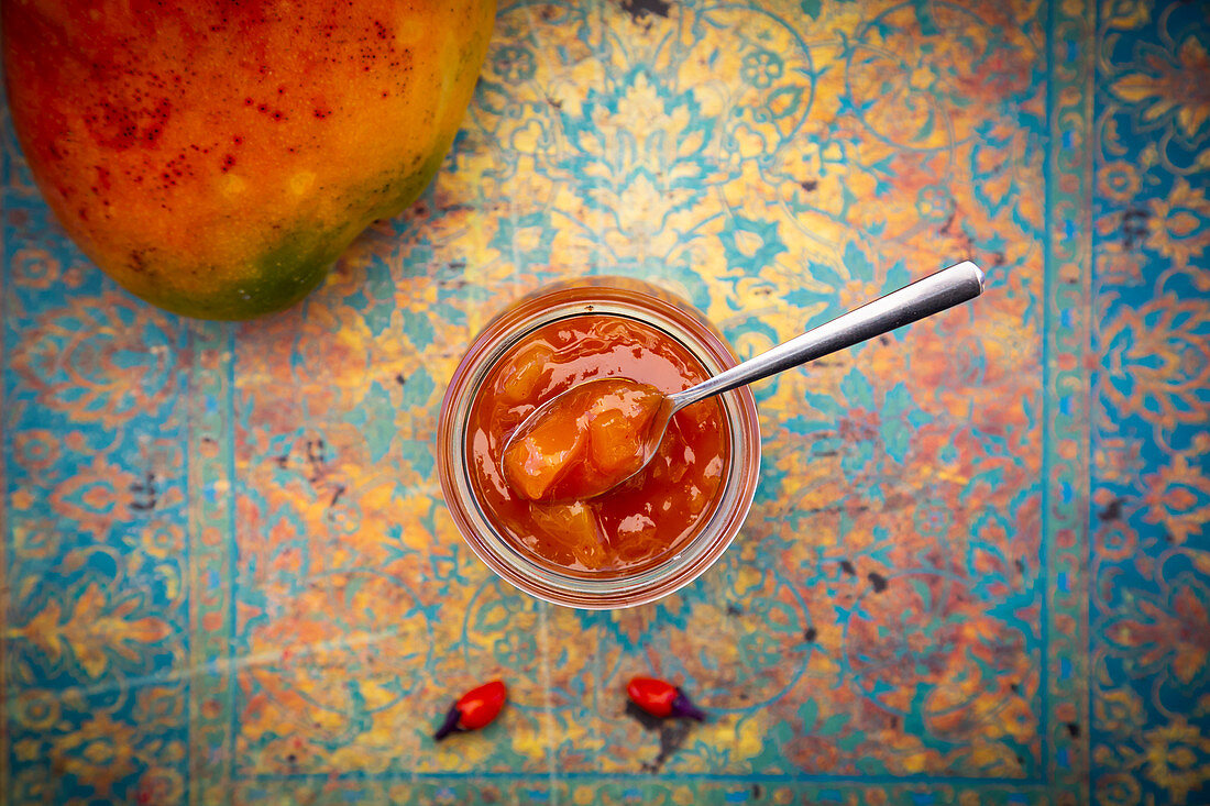 Mango chutney in a jar with a spoon